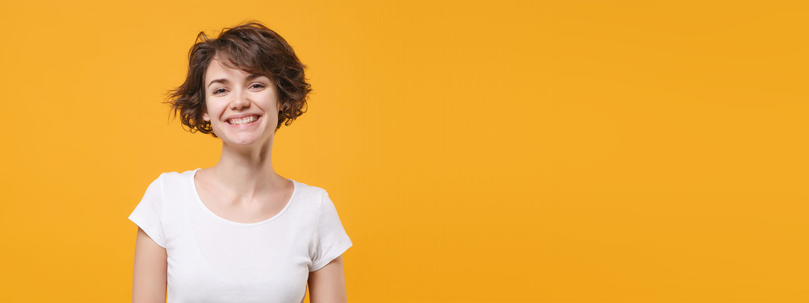 Freundliche junge Frau auf orangem Hintergrund